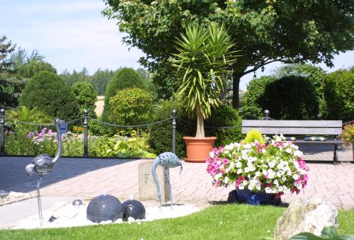 a garden with statues of swans in the grass at Gästehaus Prinzregent Luitpold in Bad Steben