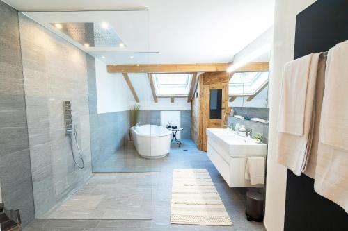 a bathroom with a tub and a toilet and a sink at Hotel & Restaurant Hasenstrick in Dürnten