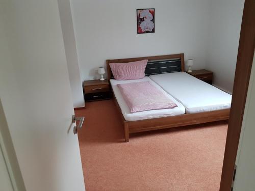 ein kleines Schlafzimmer mit einem Bett und zwei Nachttischen in der Unterkunft Apartments Haupt in Kobern-Gondorf