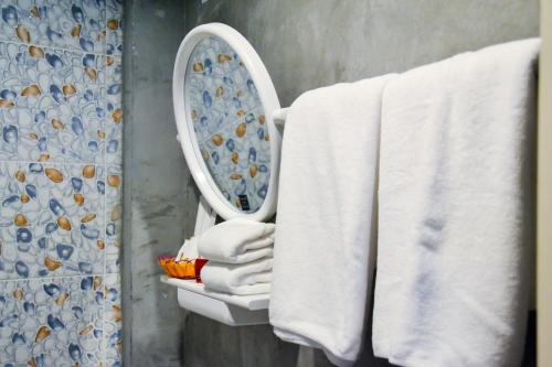a bathroom with a towel rack with a mirror at Baan Tubkaek Hotel in Tab Kaek Beach