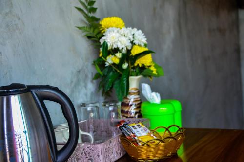a table with a vase with yellow and white flowers at Baan Tubkaek Hotel in Tab Kaek Beach