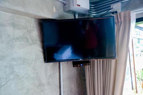 a flat screen tv hanging on a wall at Baan Tubkaek Hotel in Tab Kaek Beach