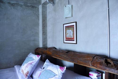 a bed with a wooden headboard in a bedroom at Baan Tubkaek Hotel in Tab Kaek Beach