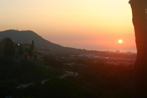 a sunset over a city with a church on a hill at B&B Premium in Premia de Dalt