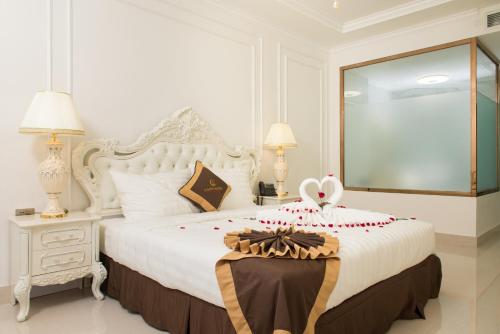a bedroom with a white bed with a bow on it at Canh Hung Palace in Hai Phong