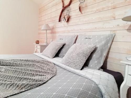 1 dormitorio con 1 cama con pared de madera en La Magie des Rêves, en Montréjeau