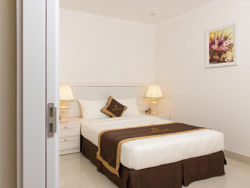 a bedroom with a large bed with white walls at Canh Hung Palace in Hai Phong