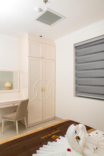 a bedroom with a white cabinet and a table with a swan at Canh Hung Palace in Hai Phong