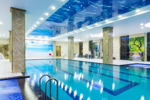 uma grande piscina com água azul num edifício em Golden Palace Hotel em Hai Phong