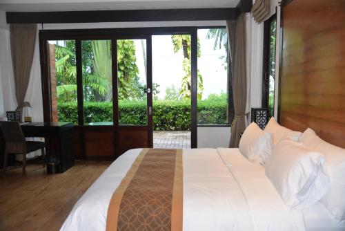 a bedroom with a large white bed and a window at Tukonnee Villas Koh Yao Noi in Ko Yao Noi