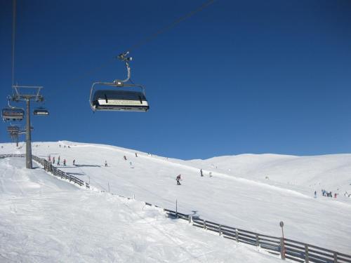 a group of people skiing down a snow covered ski slope at HH-Apartments in Scheifling