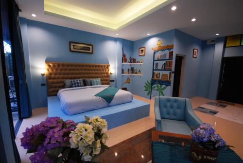 a bedroom with a bed and a chair and a table at Pupiang po Da Arte Resort in Dan Sai