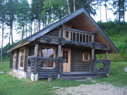 a log cabin in the middle of a field at Nuustaku Guesthouse in Otepää