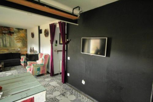 a living room with a black wall at Loboratorio Rural, La Casa de al Lado in Casas del Abad
