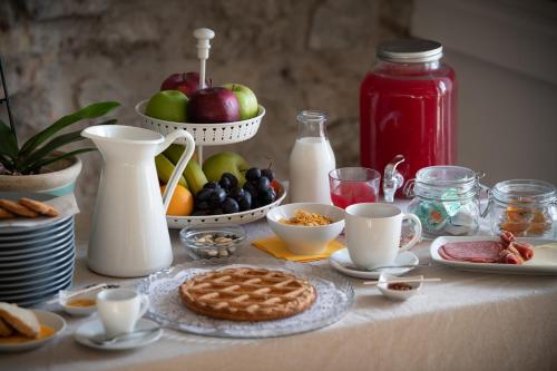 a table with cookies and fruit and milk on it at Hotel Borgo Vistalago in Trevignano Romano