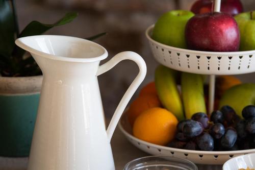 a white vase sitting next to a bowl of fruit at Hotel Borgo Vistalago in Trevignano Romano