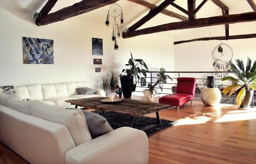 sala de estar con muebles blancos y mesa de madera en La Magie des Rêves, en Montréjeau