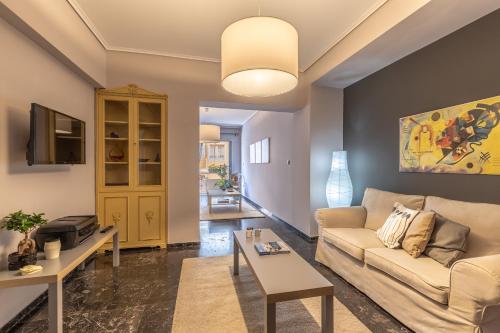 een woonkamer met een bank en een tafel bij Tranquil Central Apt, behind Athens Caravel Area in Athene