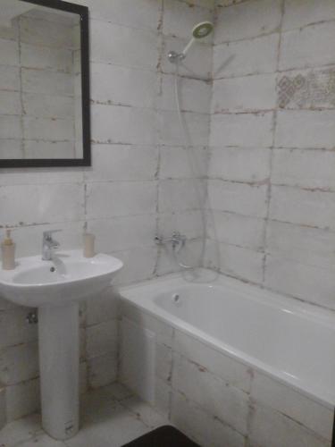 a white bathroom with a sink and a bath tub and a sink at Нова квартира in Ivano-Frankivsʼk