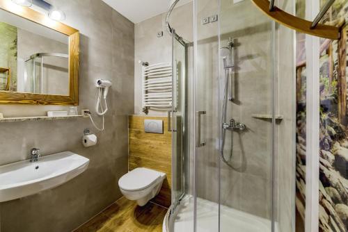 a bathroom with a shower and a toilet and a sink at Willa Roztoka & SPA - idealne miejsce dla Twojej rodziny in Bukowina Tatrzańska
