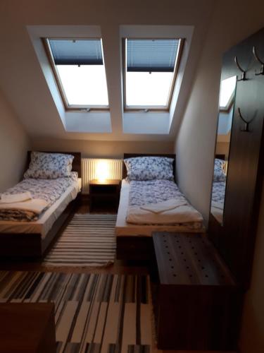 two beds in a room with two windows at Zajazd Podzamcze in Fałków