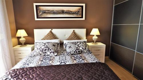 a bedroom with a bed with pillows and two lamps at Helena Seaview & Beach-apartment in Montgat
