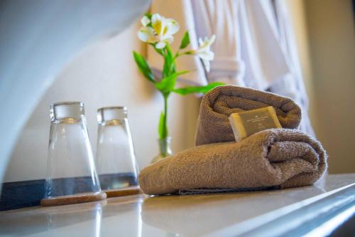 two bottles and a towel with a flower in a vase at Ayres del Champaqui Hotel Boutique Experiencial & Spa in Villa General Belgrano