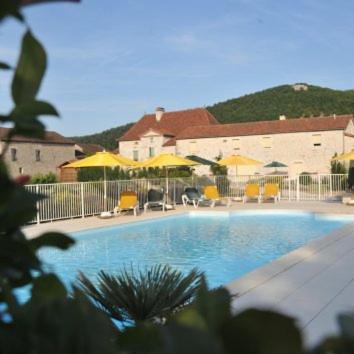 une piscine avec des parasols et des chaises jaunes dans l'établissement Le Mas de La Pommeraie, à Saint-Géry