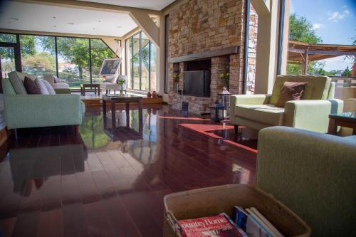 a living room with chairs and a fireplace at Ayres del Champaqui Hotel Boutique Experiencial & Spa in Villa General Belgrano