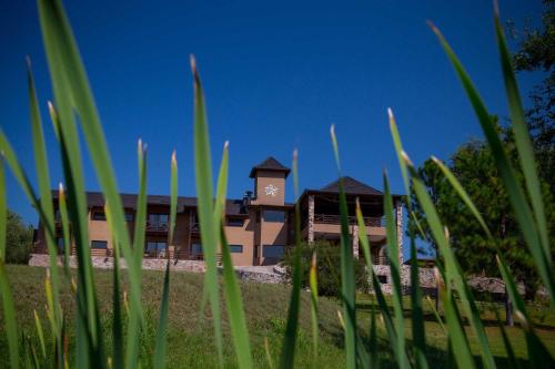 a building with a clock tower on top of it at Ayres del Champaqui Hotel Boutique Experiencial & Spa in Villa General Belgrano