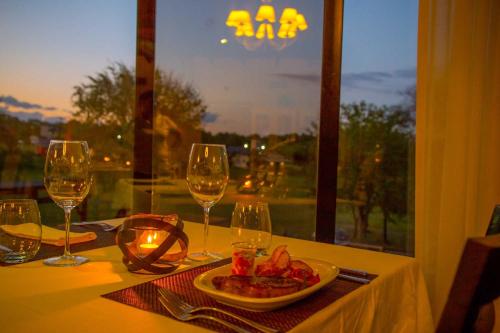a table with a plate of food and wine glasses at Ayres del Champaqui Hotel Boutique Experiencial & Spa in Villa General Belgrano