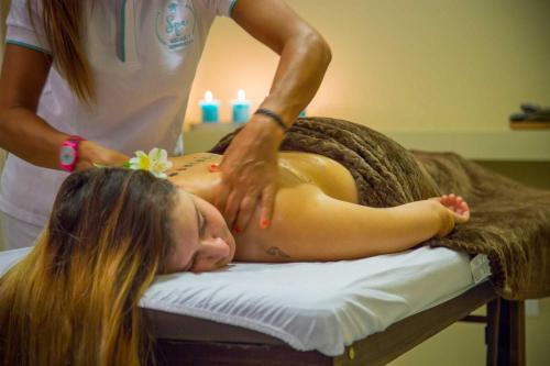 a woman getting a back massage from a therapist at Ayres del Champaqui Hotel Boutique Experiencial & Spa in Villa General Belgrano