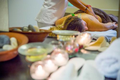a woman laying on a bed getting a massage at Ayres del Champaqui Hotel Boutique Experiencial & Spa in Villa General Belgrano