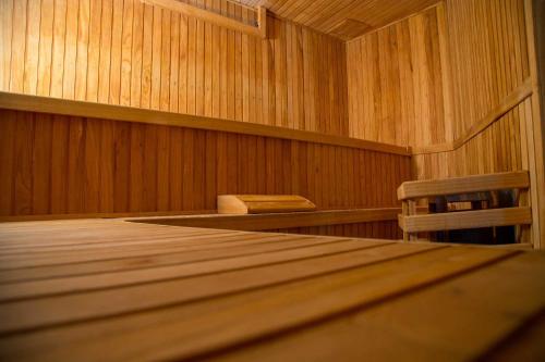 an empty sauna with a wooden floor and two chairs at Ayres del Champaqui Hotel Boutique Experiencial & Spa in Villa General Belgrano