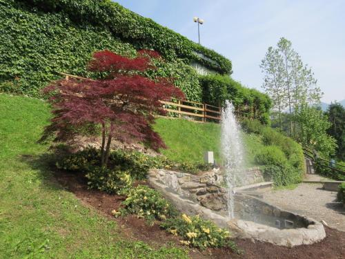a fountain in the middle of a garden at Hotel Ristorante Fatur in Cisano Bergamasco