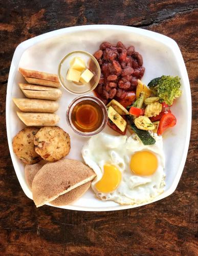 a plate of breakfast food with eggs bread and beans at Beach Street Eco Resort - Mandrem in Mandrem