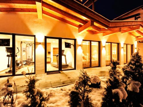 a building with snow on the ground and lights at Hotel Theresia in Ramsau im Zillertal