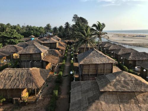 an aerial view of a village with thatched roofs at Beach Street Eco Resort - Mandrem in Mandrem