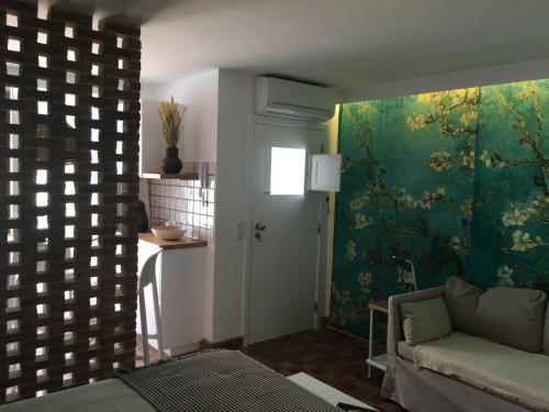 a living room with a couch and a painting on the wall at LUZZ me - Casa da Fuzeta in Fuzeta