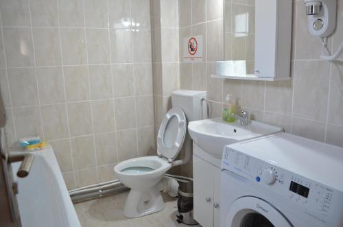 ein Badezimmer mit Toilette, Waschbecken und Waschmaschine in der Unterkunft Alexys Residence 5 in Iaşi