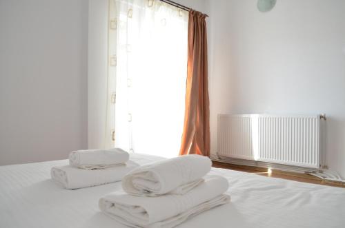 a bedroom with two white towels on a bed at Alexys Residence 4 in Iaşi