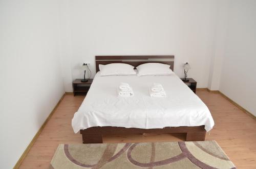 a bedroom with a white bed with two white pillows at Alexys Residence 4 in Iaşi