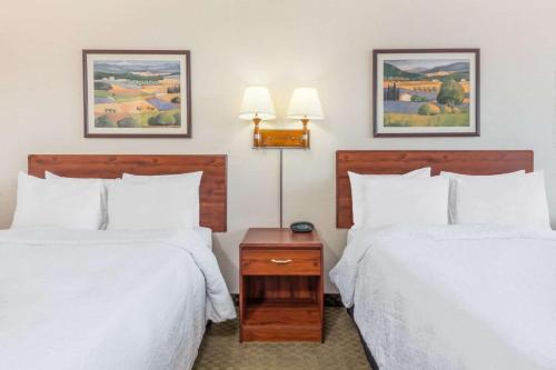 a hotel room with two beds with white sheets at Howard Johnson by Wyndham Gillette in Gillette