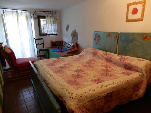 a bedroom with a bed with a quilt on it at Il Borgo della Colomba in Fosdinovo