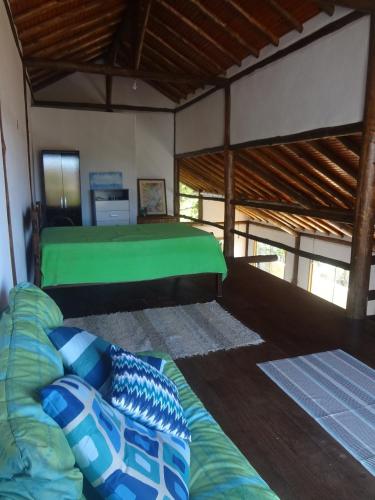a bedroom with a green bed in a room at Chalé da Estação in Carrancas