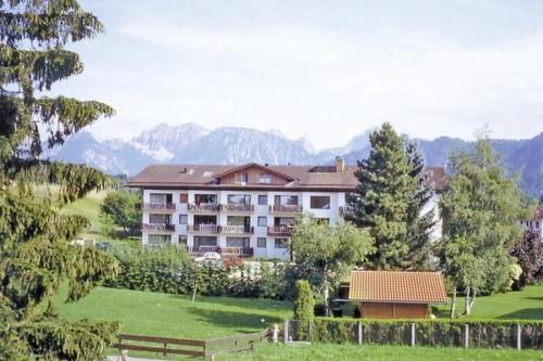 a large apartment building with mountains in the background at Sonnenhof App. 112 in Füssen