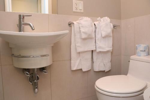 a bathroom with a sink and a toilet and towels at Cozy Newbury Street Studio, #5 in Boston