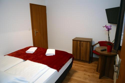 a bedroom with a bed with a red blanket on it at Willa Anna Maria in Białka Tatrzanska