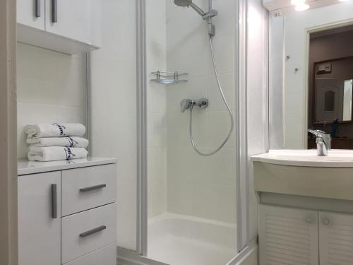 a white bathroom with a shower and a sink at Wolin-Travel Apartament Dom przy Parku in Międzyzdroje