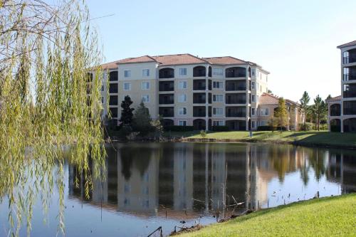 a large apartment building next to a body of water at WQR Private Rentals No Resort Pool Access in Orlando